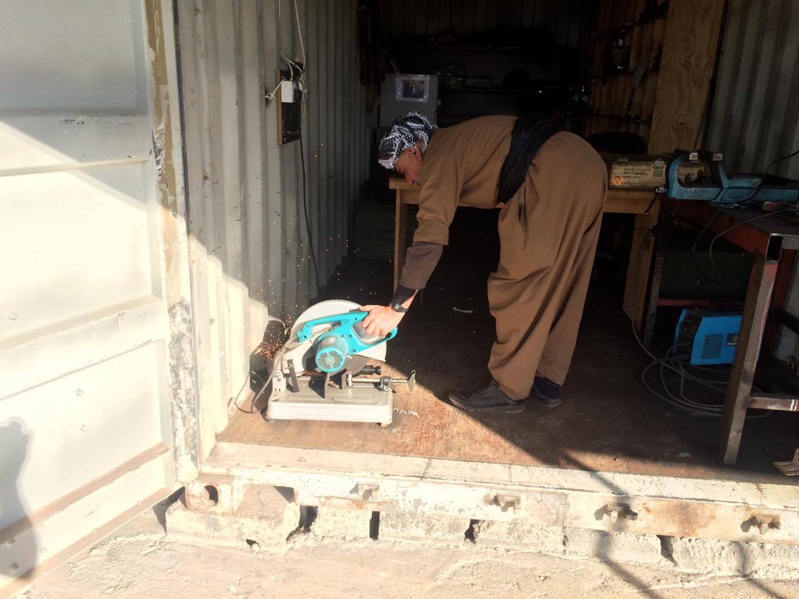 An armorer grinds down a component to the required specifications