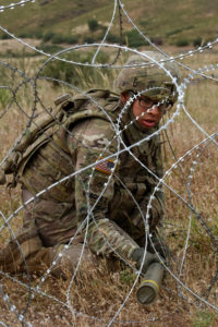 A combat engineer with A Company, 54th Brigade Engineer Battalion, of the 173rd Infantry Brigade Combat Team (Airborne) places a bangalore explosive during a range to practice breaching wire obstacles. - DVIDS