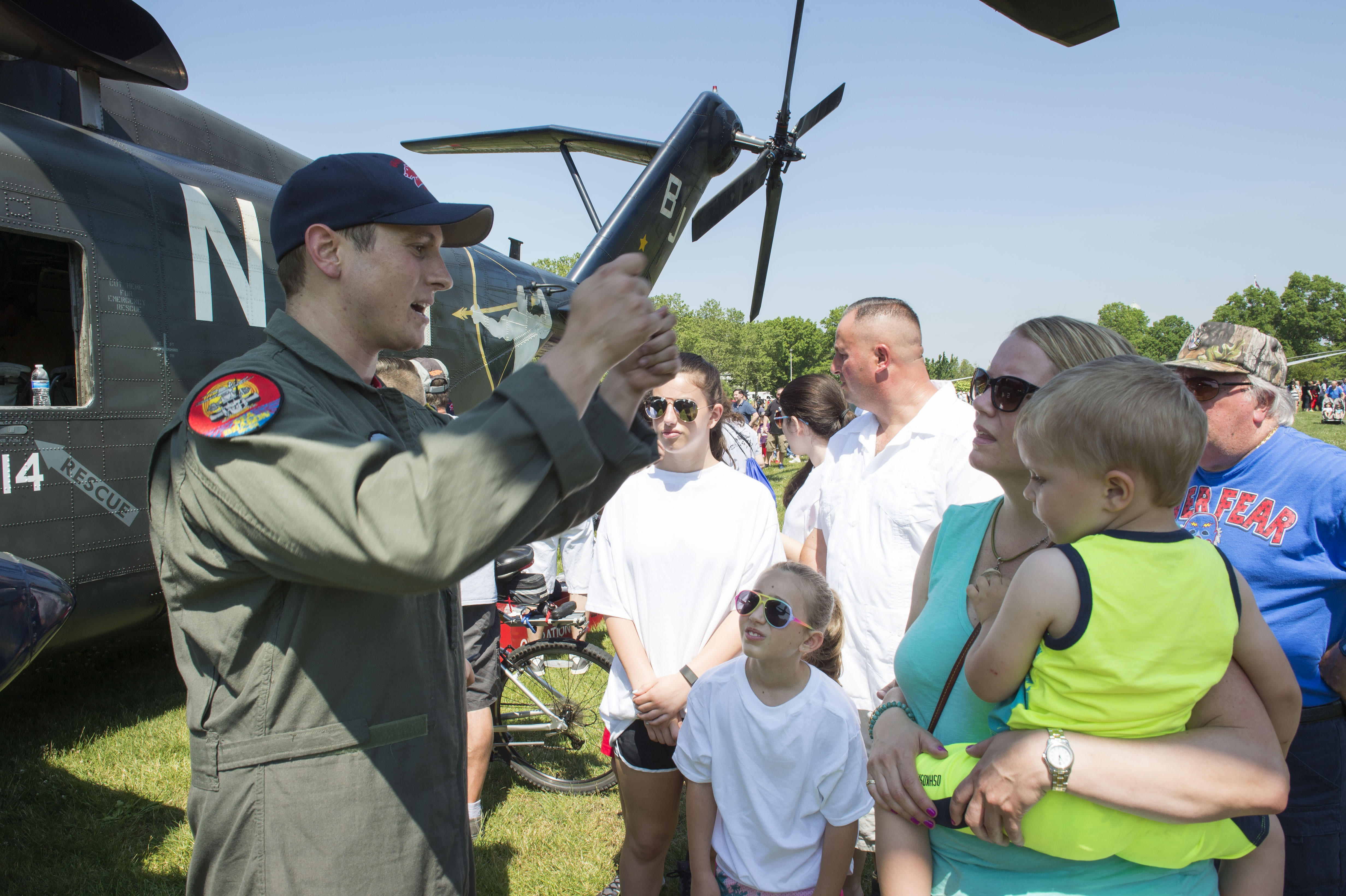 160528-N-SX684-112 EAST MEADOW, N.Y. (May 28, 2016) Navy Aircrewman 2nd Class Brandon Drew explains the lifting capability of the MH-53 Sea Dragon helicopter during an aviation demonstration at Eisenhower Park as a part of 2016 Fleet Week New York (FWNY), May 28. FWNY, now in its 28th year, is the city's time-honored celebration of the sea services. It is an unparalleled opportunity to for the citizens of New York and the surrounding tri-state area to meet Sailors, Marines and Coast Guardsmen, as well as witness firsthand the latest capabilities of today's maritime services. The weeklong celebration has been held nearly every year since 1984. (U.S. Navy photo by Mass Communication Specialist 1st Class Brian McNeal/Released)