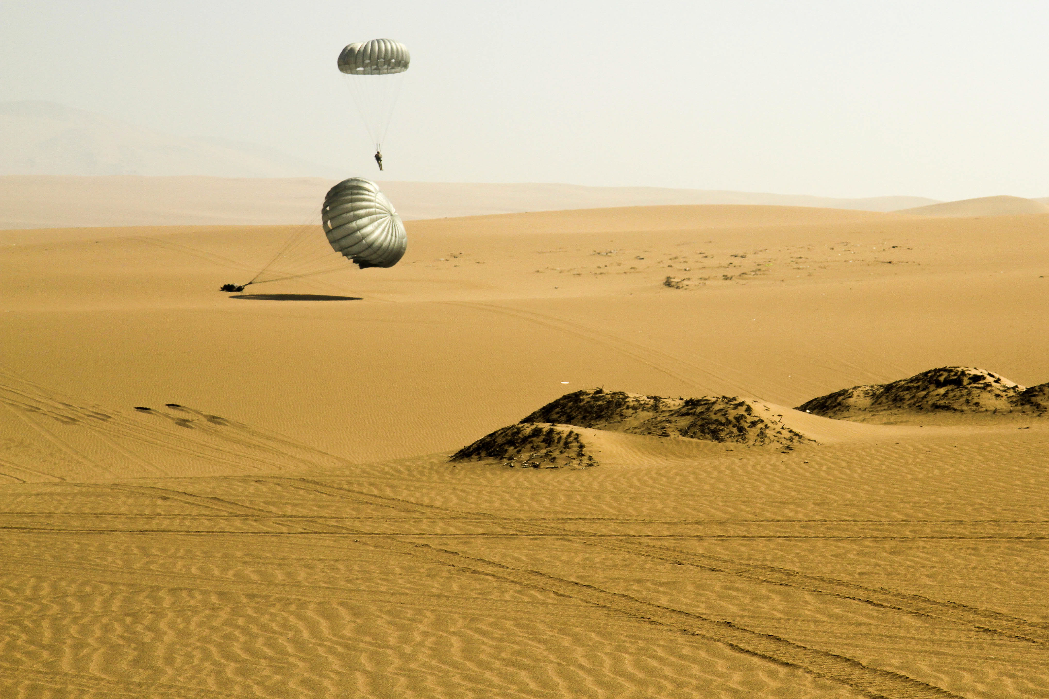 Participants of the Fuerzas Comando 2016 friendship jump land in the sandy hills surrounding Ancon, Peru on May 11, 2016. This event was part of Fuerzas Comando 2016, a multinational special operations competition that helps build joint partnerships between nations. (U.S. Army photo by Jaccob Hearn/released)