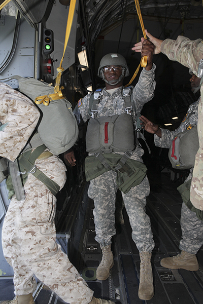 U.S. Army Pfc. Jeffery Harris, with the 982nd Combat Camera Company, East Point, Ga., hands off his static line before he exits a C-17 Globemaster III aircraft during the 75th Anniversary of Airborne School jump, at Fort Benning, Ga., Aug. 15, 2015. The 1-507th Parachute Infantry Regiment(PIR) Battalion celebrates 75 years of the U.S. Army Airborne School and the commemoration of the last qualifying jump of the first airborne test platoon on Aug. 15, 1940. (U.S. Army Photo by Spc. Joshua Talley/ Released)
