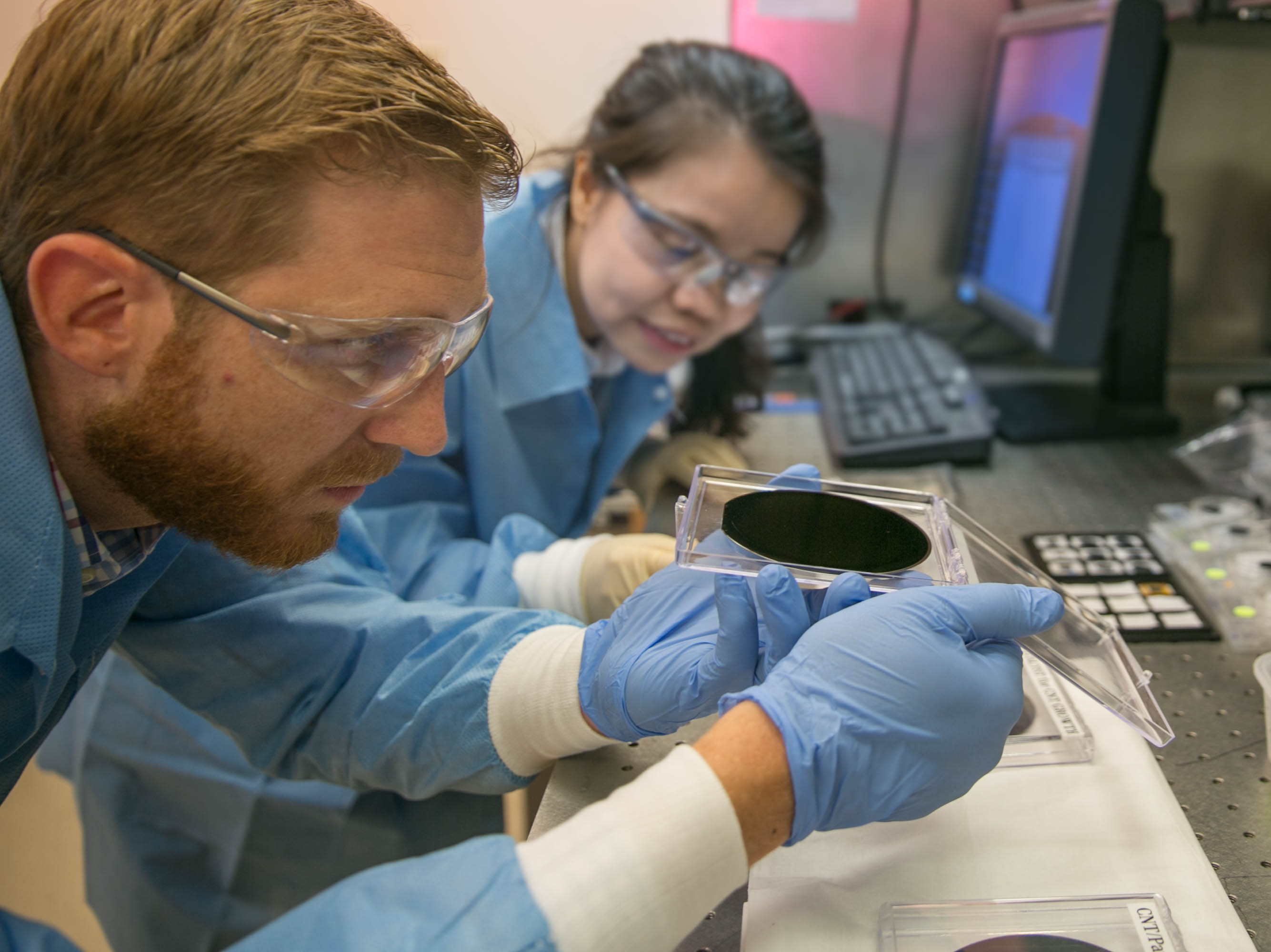 Researchers Eric Meshot, left, and Ngoc Bui evaluate the uniformity of a carbon nanotube array covering the entire area of a 4-inch wafer. Photos by Julie Rusell/LLNL.