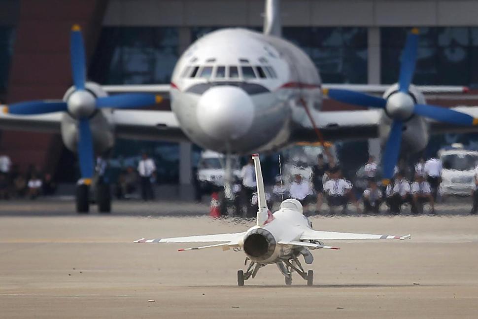 A remote-controlled F-16 fighter jet lands in front of an Air Koryo commercial airplane at the Kalma Airport after a flight demonstration on Sunday, Sept. 25, 2016, in Wonsan, North Korea. (AP Photo/Wong Maye-E)