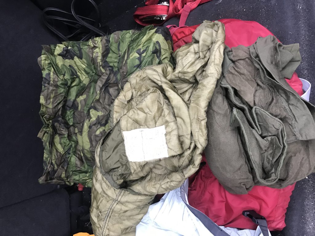 I also keep an Osprey Talon 44 pack ready for bugging out and stocked with climbing gear; the climbing gear is there because during the winters there have been numerous vehicles that spun off the road into the woods. At many junctions along the road the drop off is immense and would require someone to descend or climb out from to get help. Bugout bags have been covered as well, but mine contains some cold weather survival items that will assist in the event I am trapped in snow, or need to stay warm for hours or days. To assist in keeping warm, I have a signaling, shelter, and warmth generator such as a red-colored thermal tarp; a great item to have for these or other problems that could arise. A poncho is a must for backup shelters, and keeping the rain off, during flat tire changes. My poncho of choice is the Hazzard 4 poncho villa (https://www.hazard4.com/poncho-villa.html). The next items in the pack should be a water collector, a fire starter (magnesium is the best), a compass, and some layers of clothing to keep you dry and warm. My extra layers are in a water-proof compression sack that contains, a poncho liner, M-65 Field Jack liner, amilitary E.C.W.C.S., (Extended Climate Warfighter Clothing System) sleep shirt, and a wool balaclava.