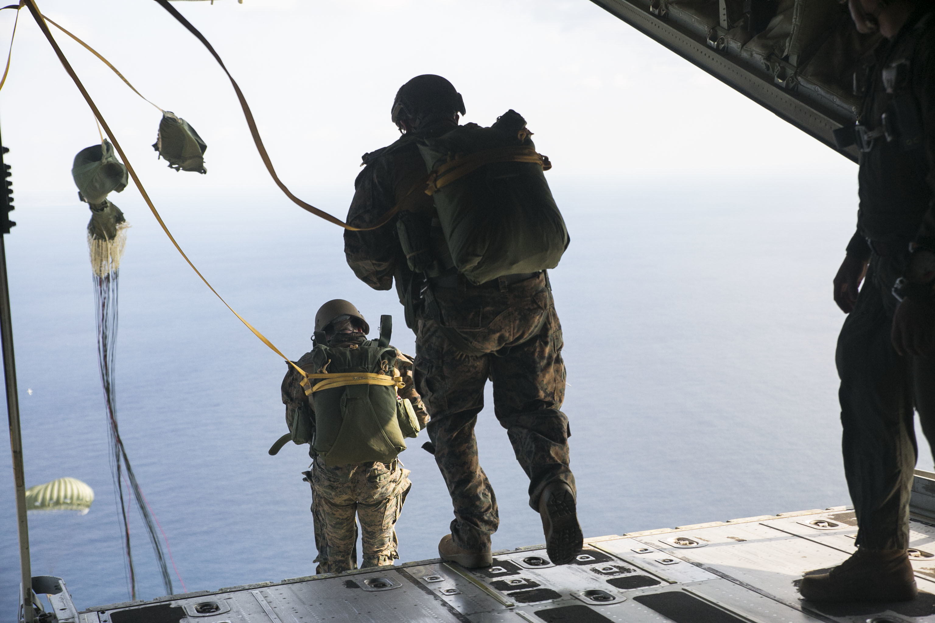 IE SHIMA, OKINAWA, Japan — Marines static line jump out of a KC-130J Super Hercules aircraft Nov. 20, 2014 over Ie Shima Training Facility, off the northwest coast of Okinawa, Japan. While performing a low level static line jump, the jumper is released from the aircraft at a low altitude and their chute is pulled open by the aircraft as they exit. The Marines did their static line jumps from an altitude of 1,500 feet for this training. The Marines are with 3rd Reconnaissance Battalion, 3rd Marine Division, III Marine Expeditionary Force. (U.S. Marine Corps photo by Cpl. Drew Tech/Released)