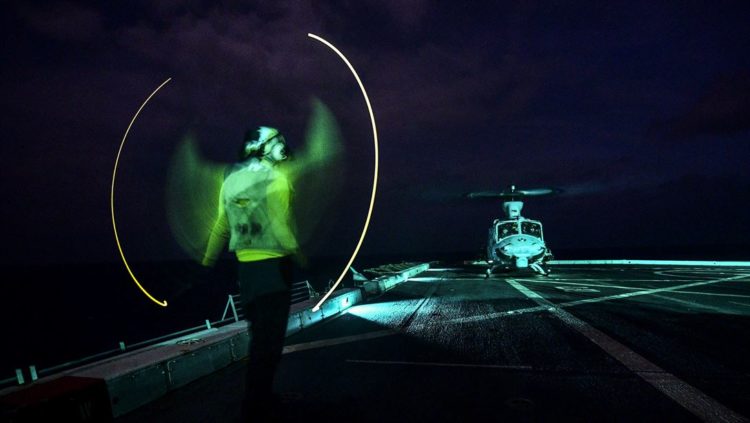 Picture of the Day: Navy Seaman Ryan Sharland Signals a UH-1Y Venom Helicopter on the USS San Diego