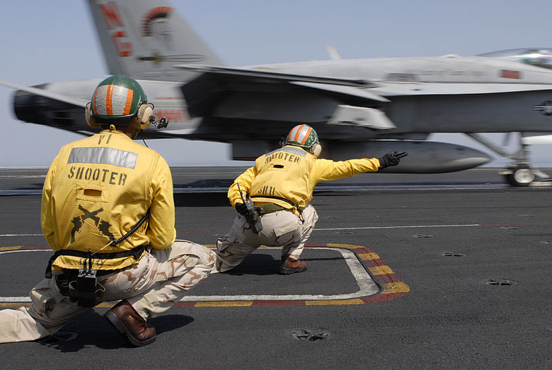 Flight deck officers, referred to as shooters, launch an F/A-18C Hornet