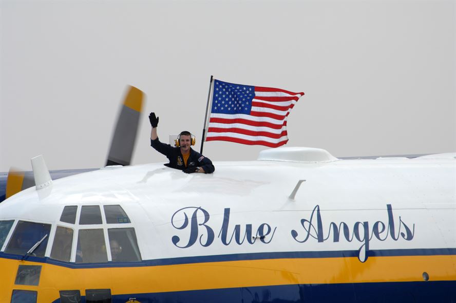 Blue Angels Fat Albert team carries an American flag