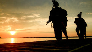 Green Berets running along water.