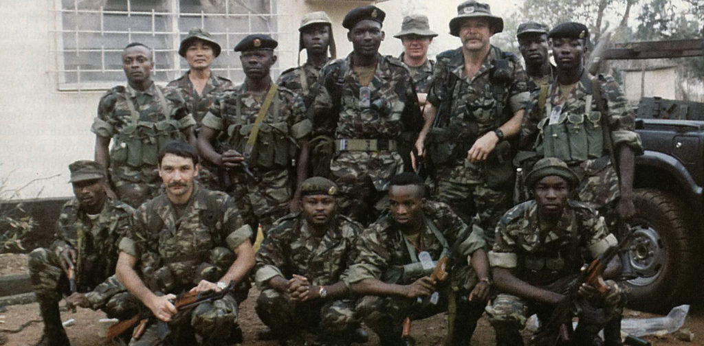 Lt. Col. Robert C. MacKenzie (standing, wings on hat) with the Sierra Leone Commandos he was training with the Gurkha Security Guards. Lt. Andy Myers is second from left, kneeling.