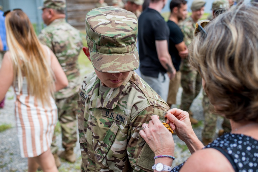 Staff Sgt. Amanda F. Kelley, assigned to the 1st Armored Division’s combat aviation brigade at Fort Bliss, Texas, gets her Ranger tab pinned on by a family member during her Ranger School graduation at Fort Benning, Georgia, Aug. 31, 2018. Kelley is the first enlisted woman to earn the Ranger tab. (U.S. Army photo by Patrick A. Albright)