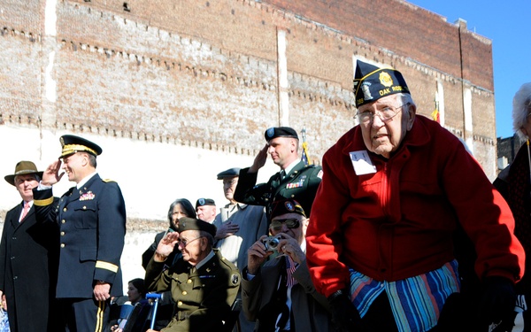 Veterans Day parade in Knoxville, Tenn, 2011. Standing in the red jacket is former WWII POW John W. Clark, who was held prisoner in Japan in Nagasaki until the atomic bomb was dropped there (DVIDS). Source: https://www.dvidshub.net/image/487388/81st-rsc-commander-attends-veterans-day-activities-knoxville 