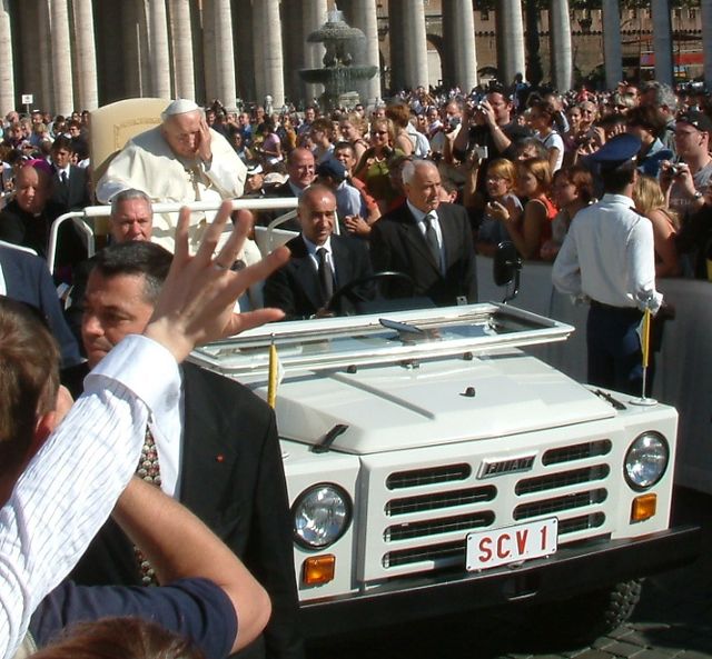 Pope John Paul with Former Inspector General of the Vatican Gendarmerie Camillo Cibin found on the left side of the popemobile, 2004 (Wikimedia Commons). Source: https://commons.wikimedia.org/wiki/File:John_Paul_II_pontifical_audience_28-09-2004.jpg