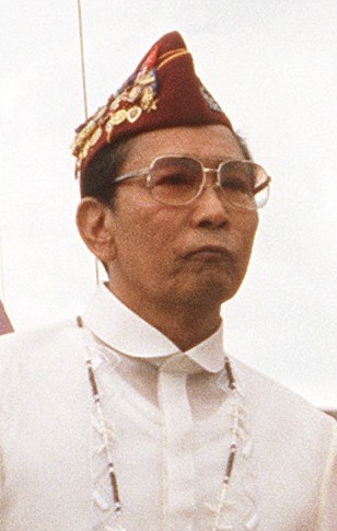 Former President Ferdinand Marcos wearing a garrison cap filled with his alleged "war medals" (Wikimedia Commons). Source: https://commons.wikimedia.org/wiki/File:Marcos_with_Bosworths.jpg