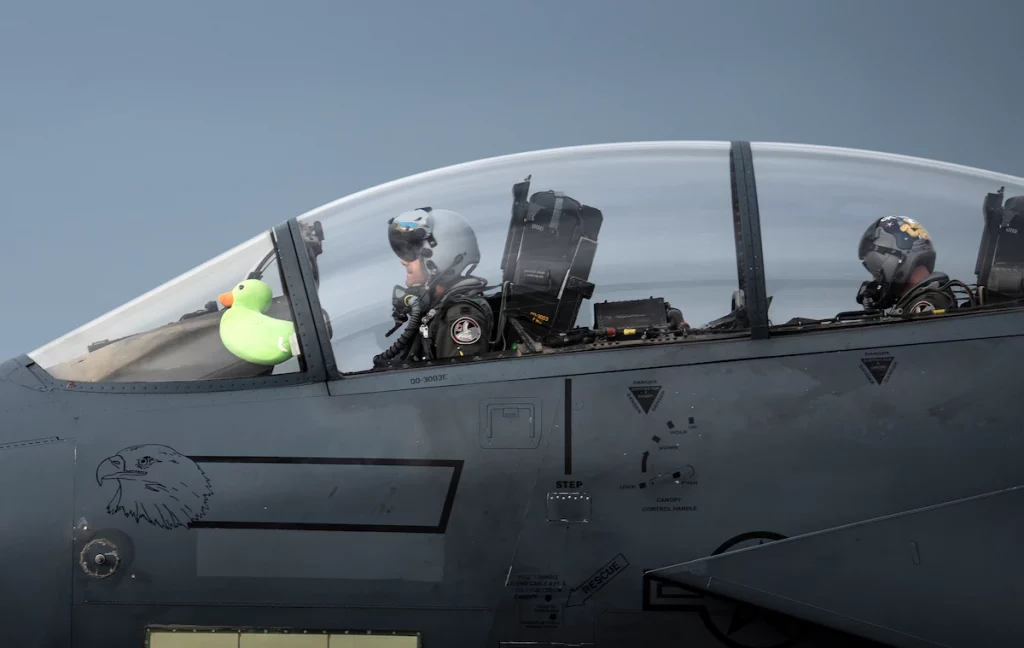 U.S. Air Force Capt. Andrew Munoz, former 494th Fighter Squadron F-15E Strike Eagle pilot and now 335th Fighter Squadron chief of plans, taxis down the runway with Scoff the Duck after returning from his final flight at Royal Air Force Lakenheath, England, Oct. 28, 2020 (Royal Air Force Lakenheath). Source: https://www.lakenheath.af.mil/News/Article-Display/Article/2480902/a-duck-that-flies-with-eagles/