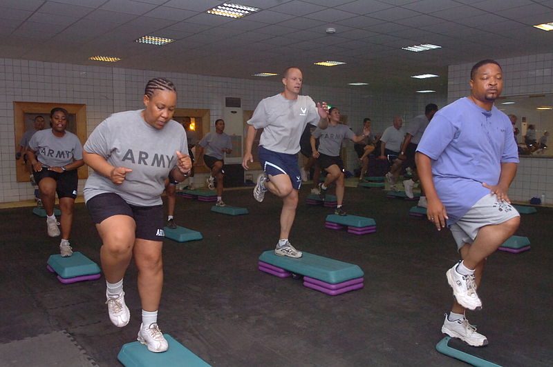 Soldiers, civilians, and Airmen who reside on Camp Taji, Iraq, enjoy a step aerobics workout