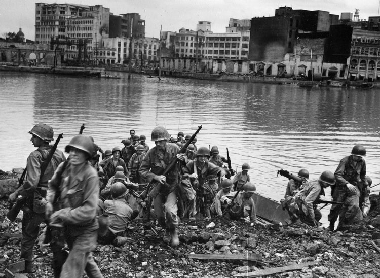 American troops crossing the Pasig River, 1945 (warfarehistorynetwork.com). Source: https://warfarehistorynetwork.com/2021/07/16/macarthurs-battle-to-liberate-manila-amid-murder-mayhem/