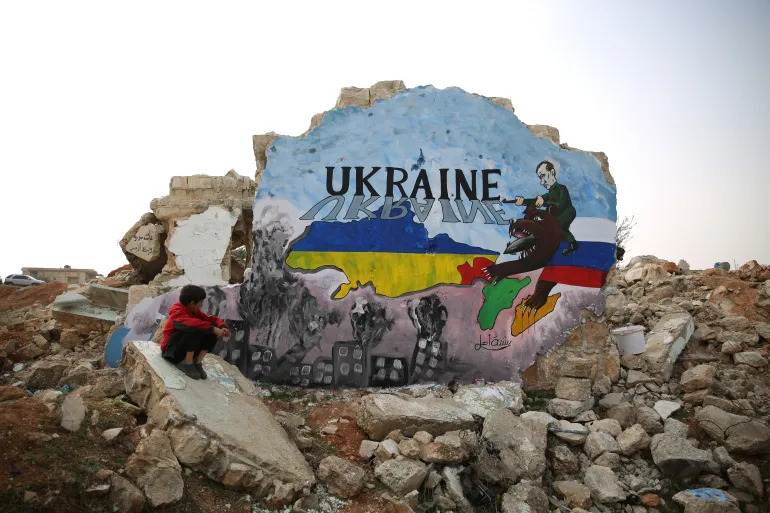 A Syrian artist in the countryside of Idlib painted a mural of solidarity with the Ukrainian people on the remaining wall of a house destroyed by Russian warplanes (Ali Haj Suleiman/Al Jazeera). Source: https://www.aljazeera.com/news/2022/2/24/syrians-stand-by-ukraine-after-russia-attack