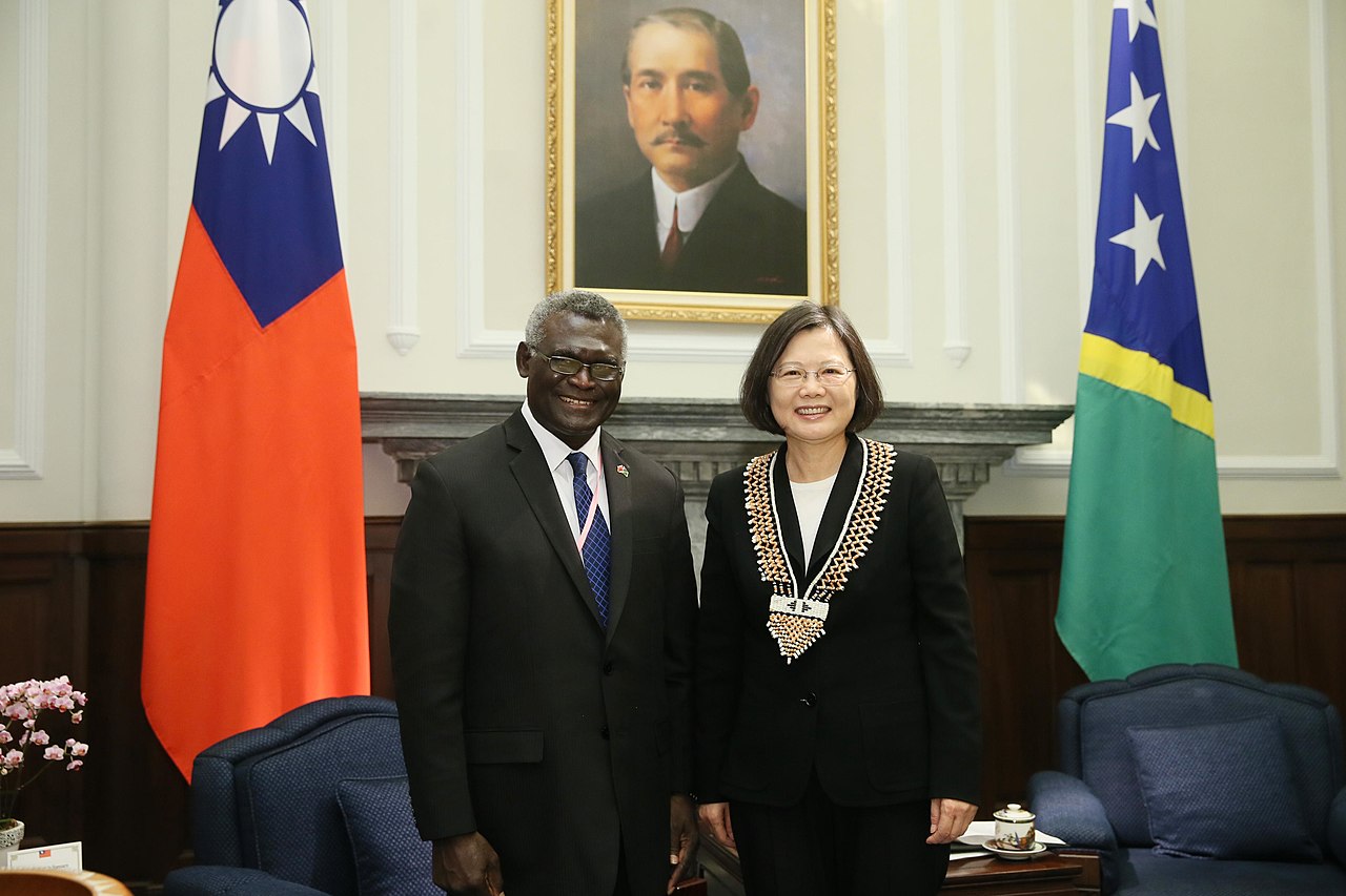 Solomon Islands Prime Minister Manasseh Sogavare with President Tsai of Taiwan (President of the Republic of China, Attribution, via Wikimedia Commons). Source: https://commons.wikimedia.org/wiki/File:%E8%94%A1%E8%8B%B1%E6%96%87%E7%B8%BD%E7%B5%B1%E6%8E%A5%E8%A6%8B%E7%B4%A2%E7%BE%85%E9%96%80%E7%BE%A4%E5%B3%B6%E7%B8%BD%E7%90%86%E8%98%87%E5%98%89%E7%93%A6%E7%91%9E%E4%BC%89%E5%84%B7%E8%A8%AA%E8%8F%AF%E5%9C%98.jpg