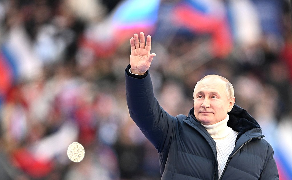 Russian Vladimir Putin giving speech during a celebration marking the anniversary of Crimea’s reunification with Russia at the Luzhniki Sports Centre in Moscow 2022 (Kremlin.ru, CC BY 4.0 , via Wikimedia Commons). Source: https://commons.wikimedia.org/wiki/File:President_Vladimir_Putin_speech_Crimea_reunification_anniversary_2022,_Pic_1.jpg