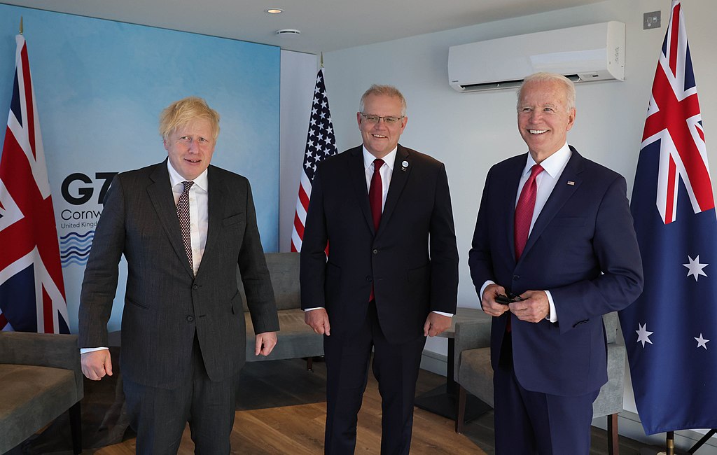 Prime Minister Boris Johnson G7 Leaders Summit Day Two. The Prime Minister Boris Johnson The President of the United States Joe Biden and the Prime Minister of Australia Scott Morrison during a meeting at the G7 Summit in Carbis Bay, Cornwall (UKinUSA from Washington, D.C., USA, CC BY-SA 2.0 <https://creativecommons.org/licenses/by-sa/2.0>, via Wikimedia Commons). Source: https://commons.wikimedia.org/wiki/File:Prime_Minister_Boris_Johnson_G7_Leaders_Summit_Day_Two_(51785562781).jpg