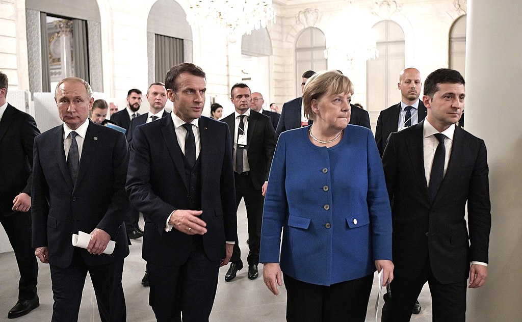 From left to right: Russian President Vladimir Putin, French President Emmanuel Macron, Former German Chancellor Angela Merkel, and Ukrainian President Volodymyr Zelensky (Kremlin.ru, CC BY 4.0 , via Wikimedia Commons). Source: https://commons.wikimedia.org/wiki/File:Putin,_Macron,_Merkel,_Zelensky_(2019-12-10)_01.jpg