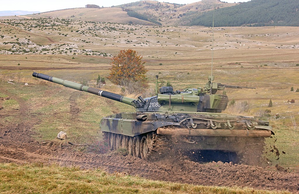 Tank M-84 of the Serbian Army during the military exercise "Cooperation 2020" on Peshter. The joint tactical exercise "Cooperation 2020" was performed at the temporary Peshter training ground with the participation of over 2,800 members of the Serbian Army, 150 different combat and non-combat vehicles and 40 aircraft (Srđan Popović, CC BY-SA 4.0 <https://creativecommons.org/licenses/by-sa/4.0>, via Wikimedia Commons). Source: https://commons.wikimedia.org/wiki/File:Sadejstvo_2020_-_M-84_VS_03.jpg