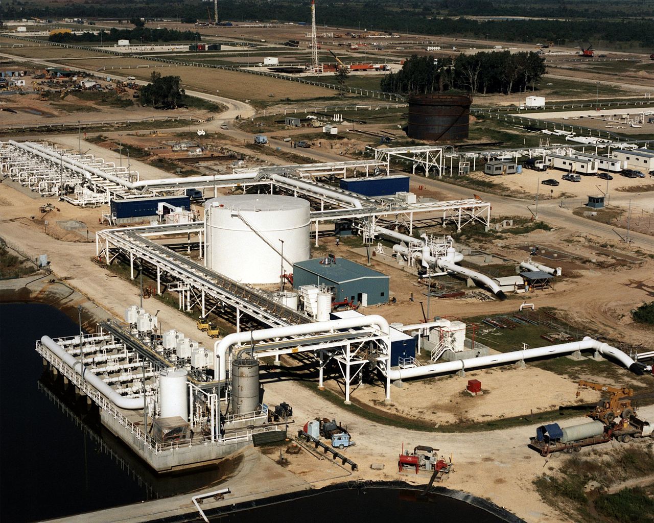 A portion of the Strategic Petroleum Reserve featuring an aerial view of high pressure pump pads, crude oil separator pond, and a brine pond (ENERGY.GOV, Public domain, via Wikimedia Commons). Source: https://commons.wikimedia.org/wiki/File:United_States_Strategic_Petroleum_Reserve_098.jpg
