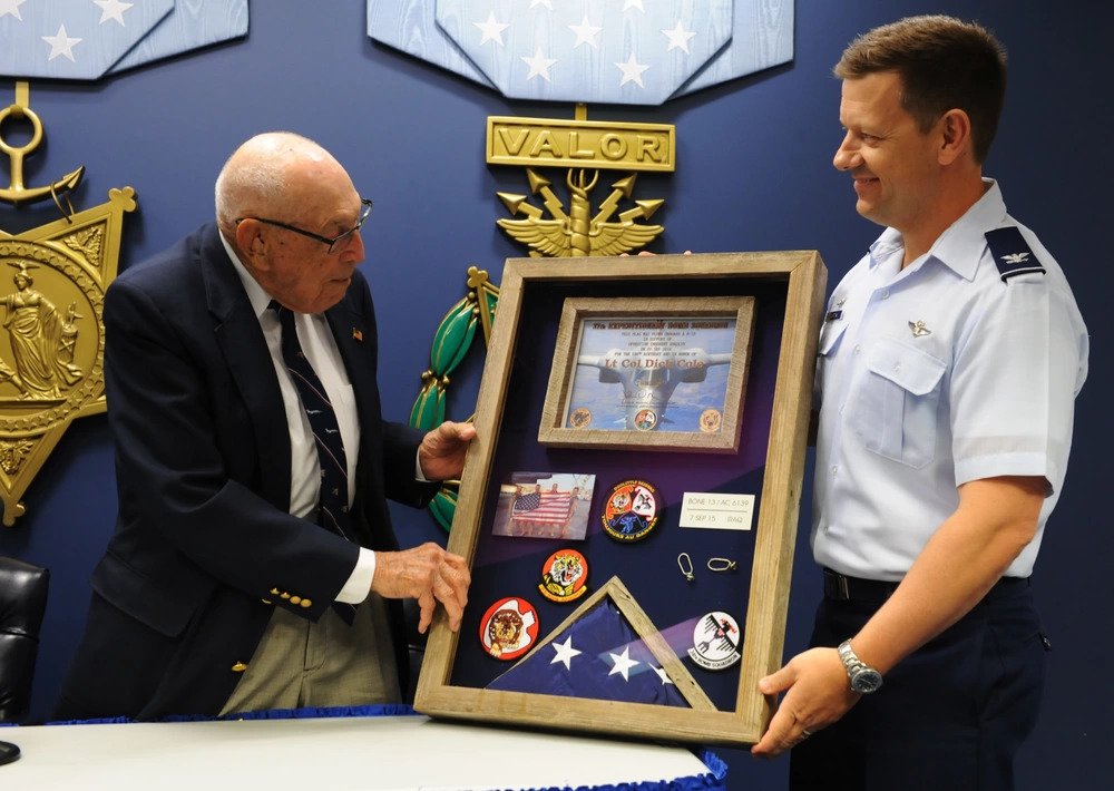 Ret. Lt. Col. Richard "Dick" Cole presented a shadow box from Col. John Martin (U.S. Air Force photo by Staff Sgt. Carlin Leslie/Released). Source: https://www.dvidshub.net/image/2270178/doolittle-raider-retired-lt-col-richard-cole