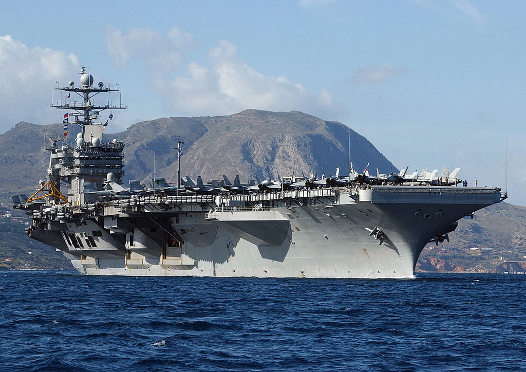The Nimitz-class aircraft carrier USS Harry S. Truman (CVN 75) sails out of Souda harbor in Crete, Greece, following a four-day port visit to Greece's largest island, 2004 (U.S. Navy photo by Paul Farley. (RELEASED), Public domain, via Wikimedia Commons). Source: https://commons.wikimedia.org/wiki/File:USS_Harry_S._Truman_(CVN_75)_departing_Greece.jpg
