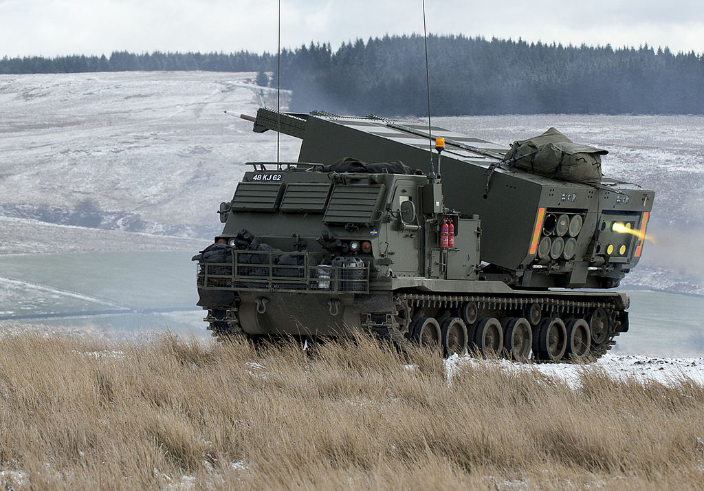 A British MLRS in Otterburn Ranges in the North of England as part of a military training exercise (Cpl Jamie Peters RLC, OGL v1.0OGL v1.0, via Wikimedia Commons). Source: https://commons.wikimedia.org/wiki/File:MLRS_firing_on_the_ranges_at_Otterburn._MOD_45158572.jpg