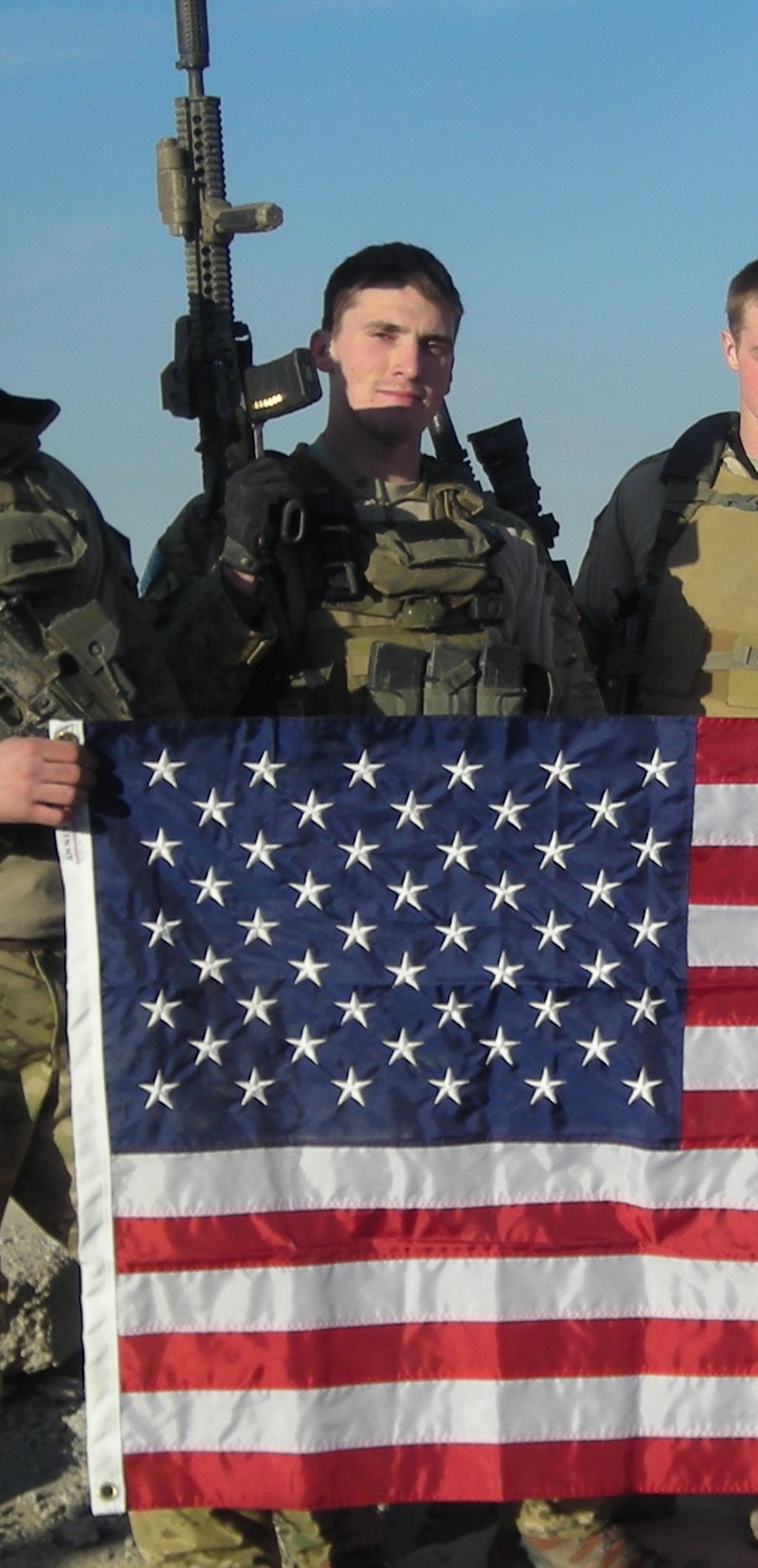 Dan is shown here with his weapon and an American flag.