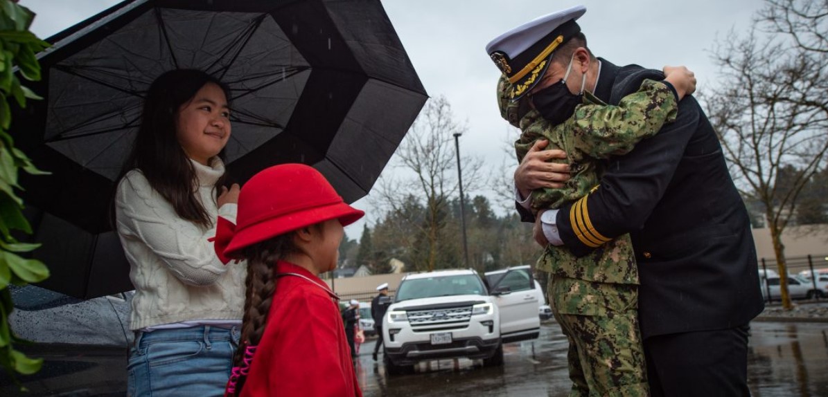 Cmdr. David Taylor, from Honolulu, Hawaii, assigned to the aircraft carrier USS Nimitz (CVN-68), greets his family following his return from deployment. US Navy Photo