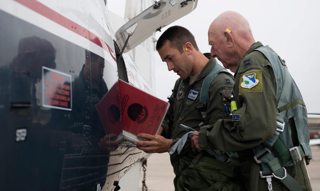 Capt. Steven Parsons, 47th Student Squadron assistant director of operations, and Jerry Yellin, author and retired U.S. Army Air Corps Captain, go over the aircraft forms before their flight in a T-6A Texan II on Laughlin Air Force Base, Texas, Dec. 15, 2016. The aircraft forms include all maintenance performed on the aircraft. (U.S. Air Force photo/Senior Airman Ariel D. Partlow)