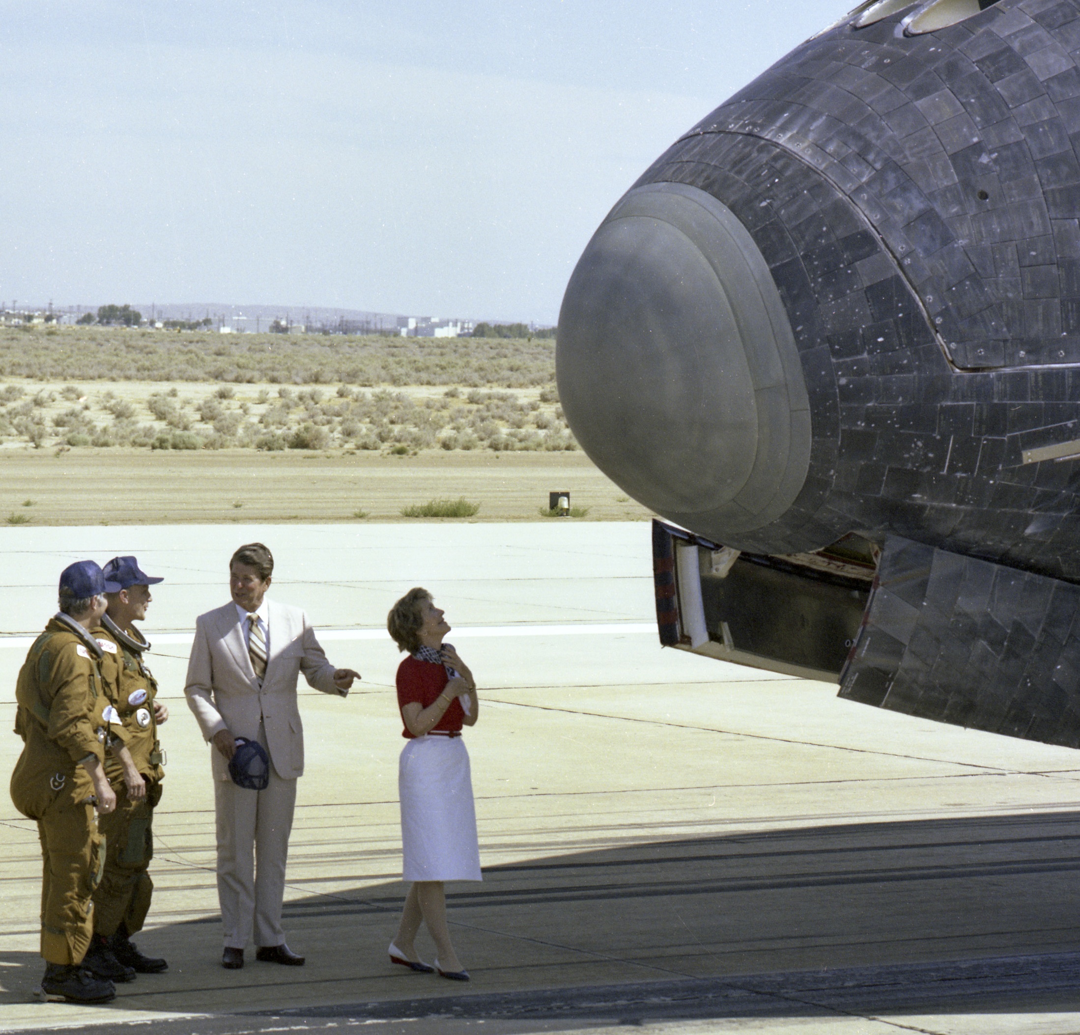 President Ronald Reagan chats with NASA astronauts Henry Hartsfield and Thomas Mattingly on the runway as first lady Nancy Reagan scans the nose of space shuttle Columbia following its Independence Day landing at Edwards Air Force Base on July 4, 1982.