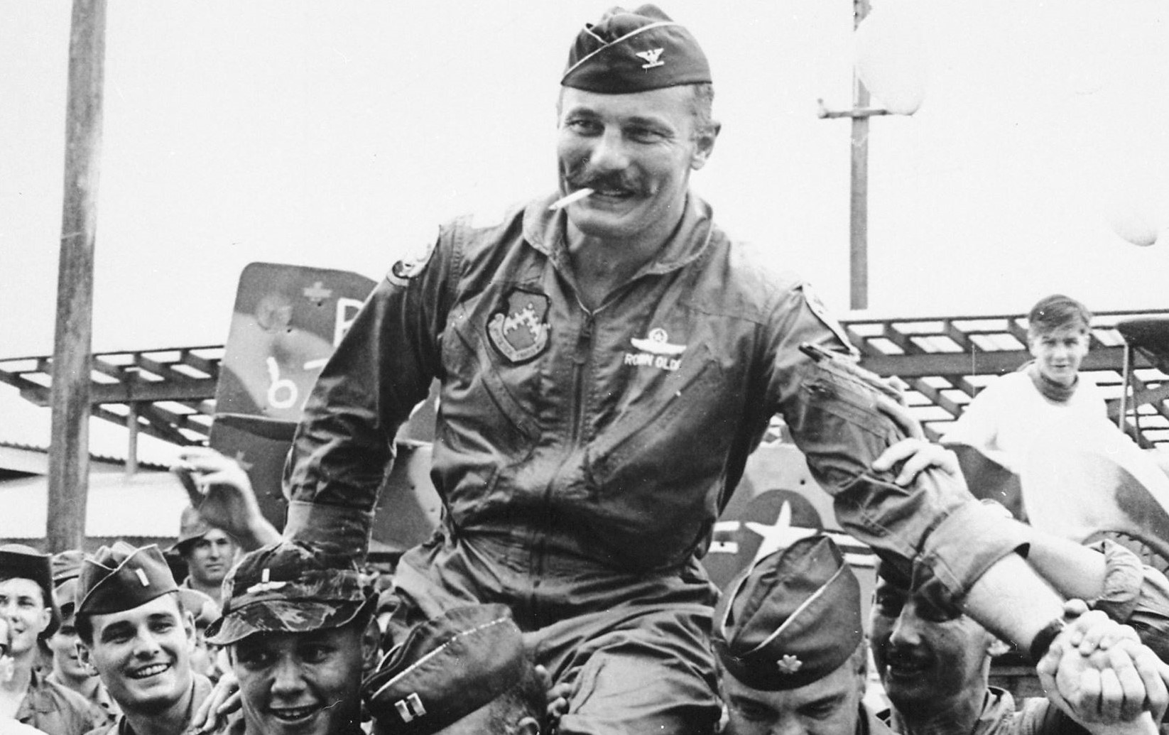 Robin Olds being lifted by his men.